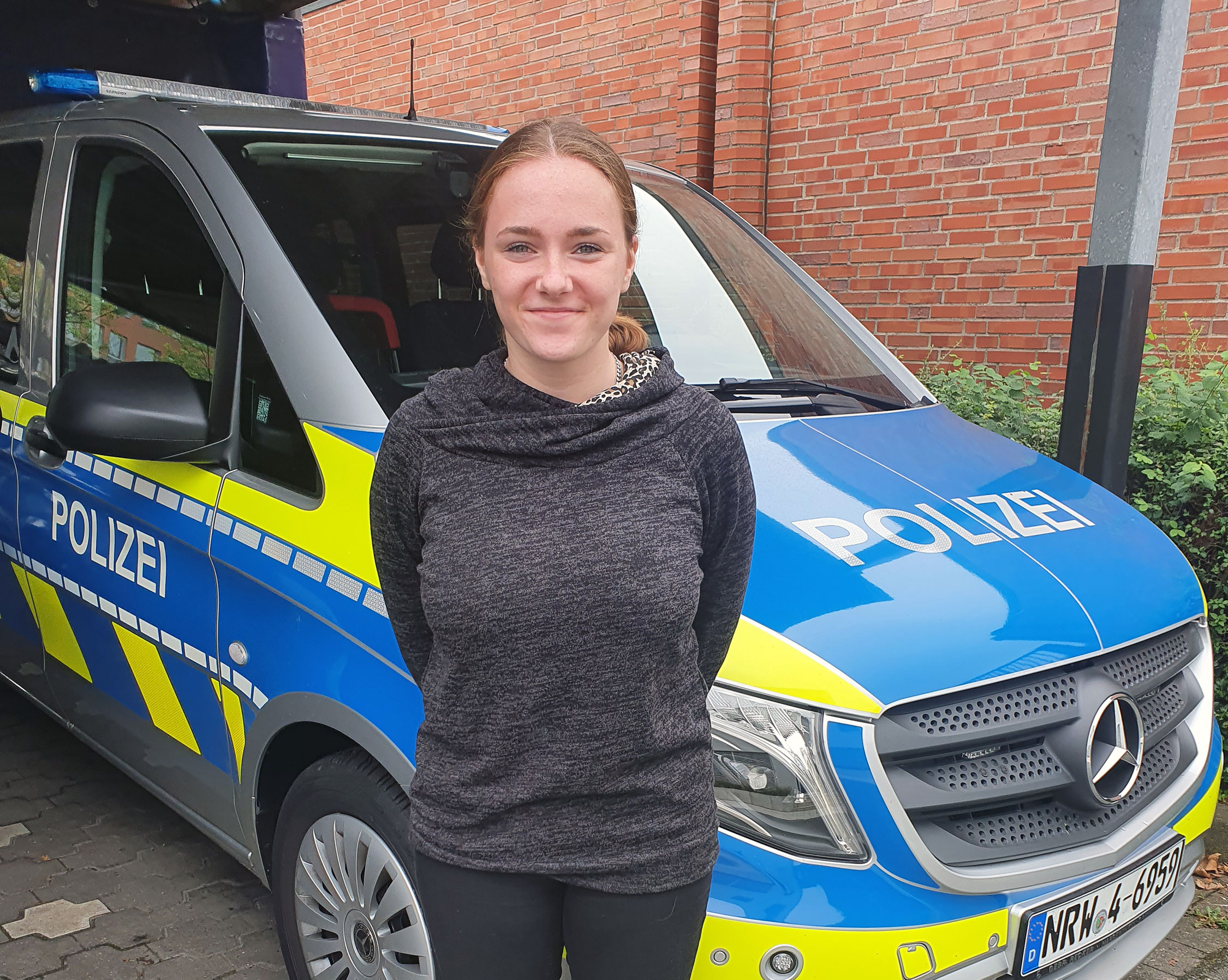 Trainee in front of a police car