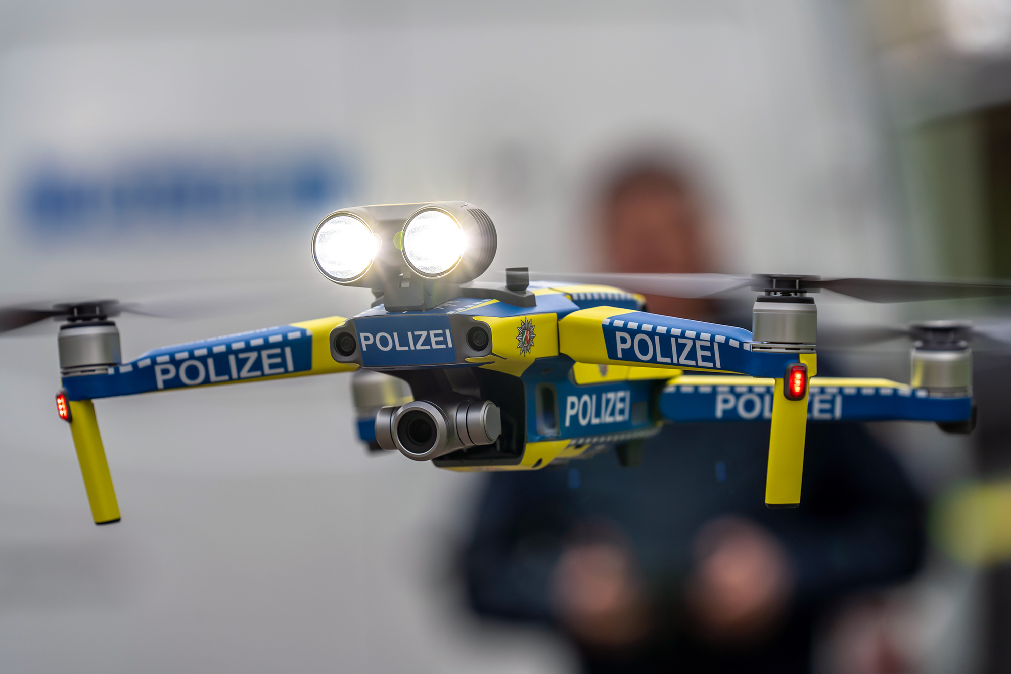 Fliegende Polizeidrohne mit beleuchteten Scheinwerfern in einem Raum