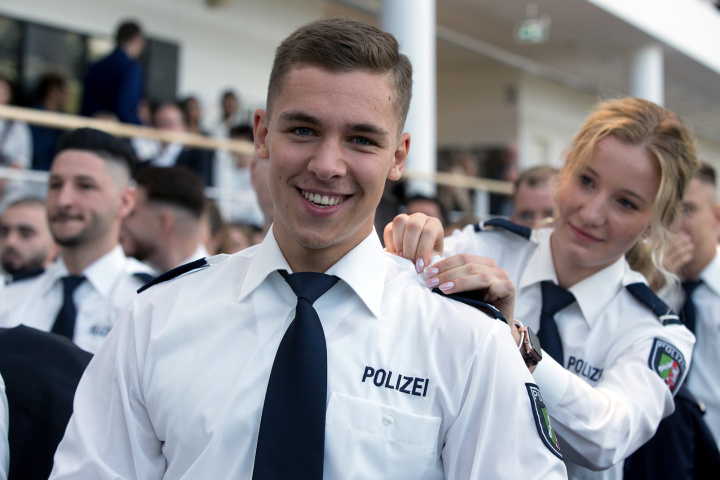 Junge Kommissarin stecke vor ihr sitzendem Kollegen die Schulterklappe ans Hemd