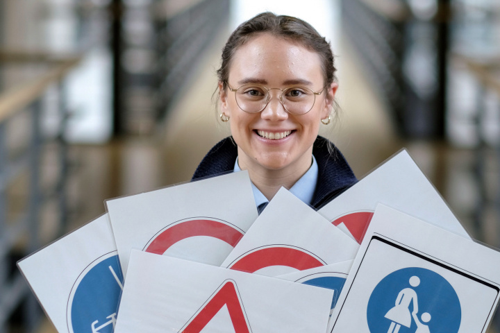 Woman holding various traffic signs in her hands