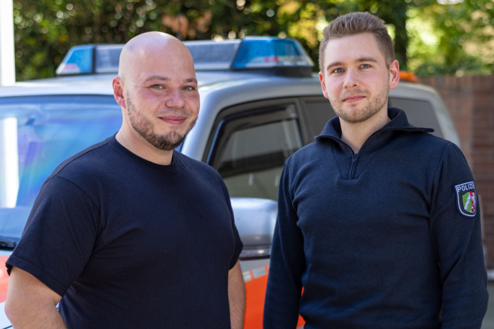 Two paramedics in front of emergency vehicle