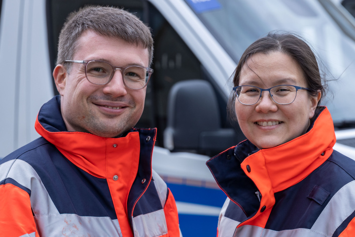 Two emergency paramedics in front of police vehicle