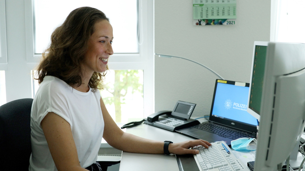 Frau Sobota sitzt vor einem Computer an ihrem Schreibtisch im Büro und schaut auf den Bildschirm.