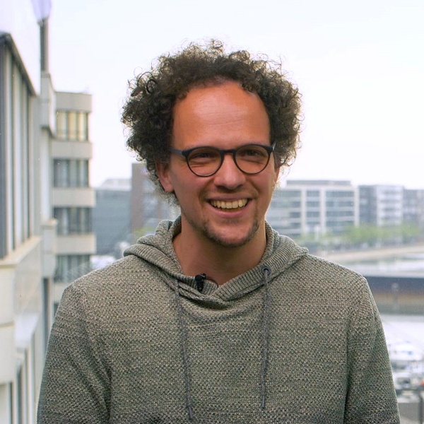 Sven Hungenberg sitz mit dem Rücken zum Fenster auf einem Fensterbrett