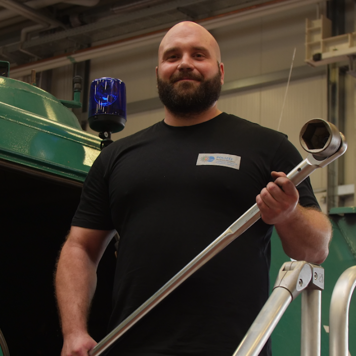 Benedikt Braeuker with a tool on an emergency vehicle