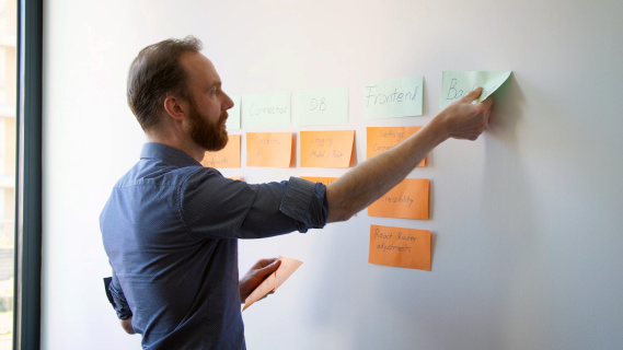 Robert Kahr beim Anbringen von Postits auf einem Whiteboard