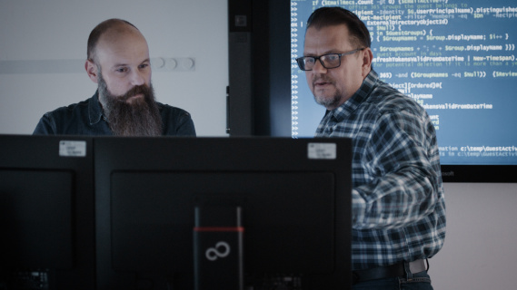 Two men in front of a monitor